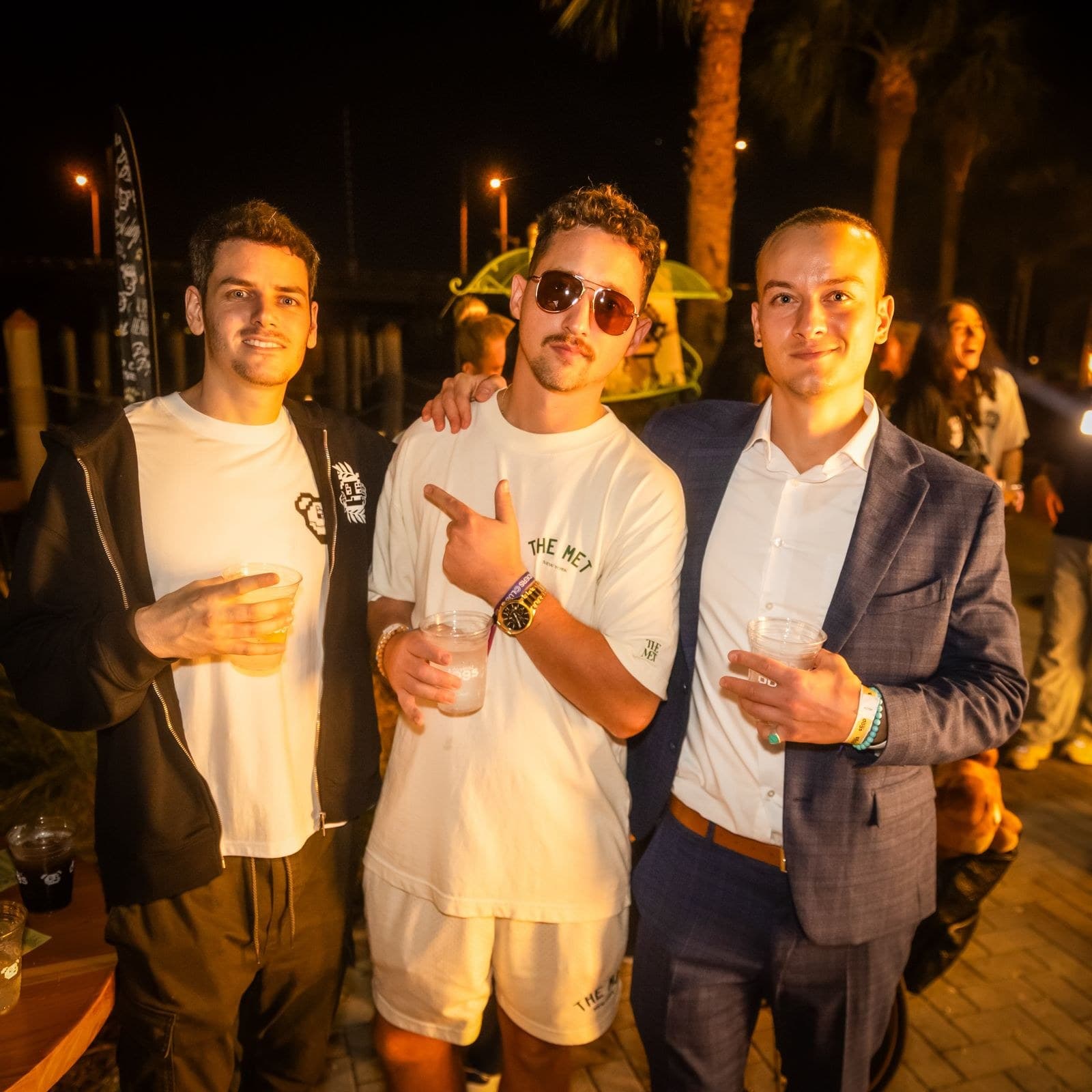 Hayden Harris with friends at night Hayden Harris (@gambitmeta) outdoors at night with friends, holding a drink